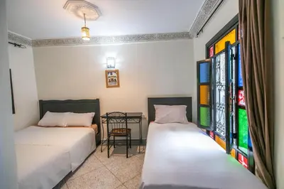 two beds in a room with stained glass windows at 105 Kasbah de Boujloud Fes Morocco. in Fès