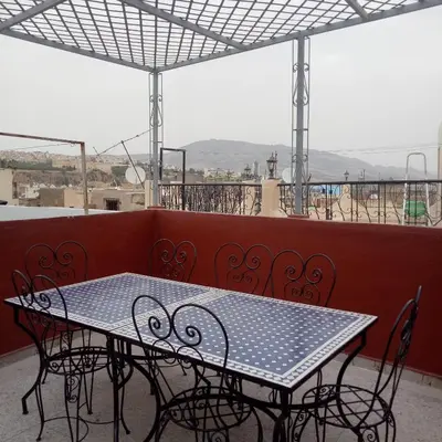 a table and chairs on top of a balcony at 105 Kasbah de Boujloud Fes Morocco. in Fès