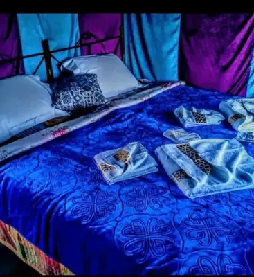 a bed with blue sheets and pillows on it at chez zakaria à Merzouga in Merzouga