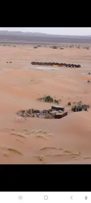 a desert with a group of buildings in the sand at chez zakaria à Merzouga in Merzouga