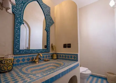 a bathroom with a sink with a mirror and a toilet at Riad Chebbi in Merzouga