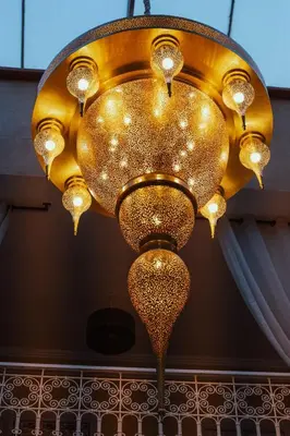 a large gold chandelier hanging from a ceiling at Riad Chebbi in Merzouga