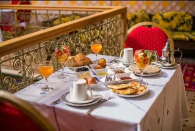 a table with food and glasses of orange juice at PALAIS LARAICHI Riad la porte bleue suites in Fès