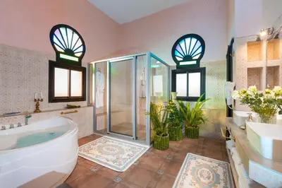 a bathroom with a tub and a shower and a sink at La Citadelle Marrakech in Marrakech