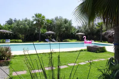 a swimming pool with a pink flamingo in a yard at La Citadelle Marrakech in Marrakech