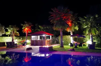 a pool with a gazebo and palm trees at night at La Citadelle Marrakech in Marrakech