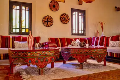 a living room with a red couch and two tables at Le Rubis Oriental Marrakech in Azib Oulad Lâdem