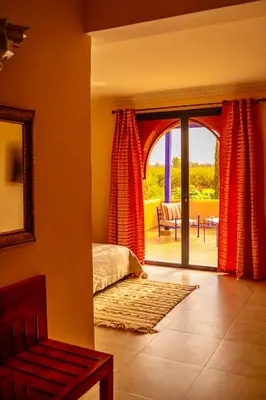 a bedroom with a bed and a sliding glass door at Le Rubis Oriental Marrakech in Azib Oulad Lâdem