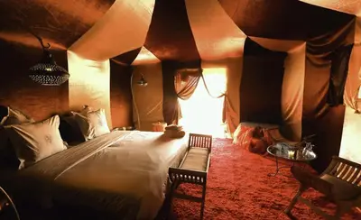 a bedroom with a bed in a room with a ceiling at Le Pacha Luxury Desert Camp - Mhamid Sahara Activities in Mhamid