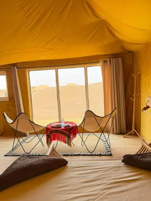 a room with two chairs and a tent at Le Pacha Luxury Desert Camp - Mhamid Sahara Activities in Mhamid