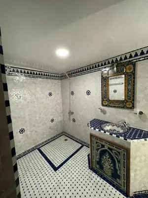 a bathroom with a sink and a tiled floor at Riad Ranya in Fès