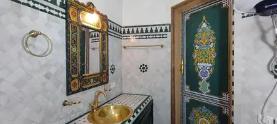 a bathroom with a gold sink and a shower at Riad Ranya in Fès