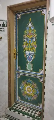 a door with a painting on it in a bathroom at Riad Ranya in Fès