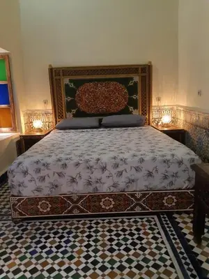 a bedroom with a bed with a large headboard at Riad Ranya in Fès
