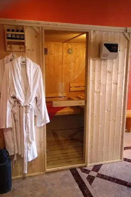 a small wooden room with a robe hanging in it at Boutique Hôtel palais Masandoia in Erfoud
