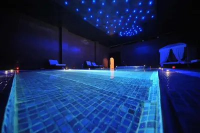 a large swimming pool with blue lights in a room at Boutique Hôtel palais Masandoia in Erfoud