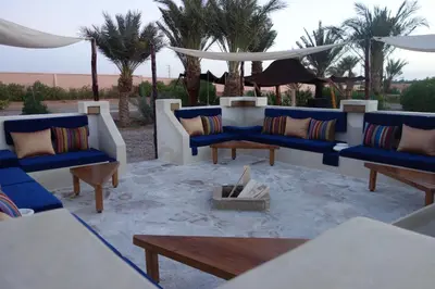 a patio with blue couches and a table at Boutique Hôtel palais Masandoia in Erfoud