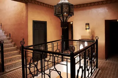 a hallway with a staircase with a chandelier at Riad Bouchedor in Ouarzazate