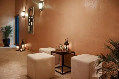 a room with two stools and a table with glasses on it at Riad Bouchedor in Ouarzazate
