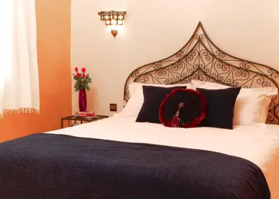 a bed with a red bow on top of it at Riad Bouchedor in Ouarzazate
