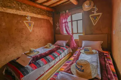 two beds in a room with hats on them at Dar Bejmate - Chez Hassan in Tacheddirt
