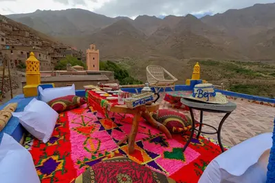 a patio with a table and a view of mountains at Dar Bejmate - Chez Hassan in Tacheddirt