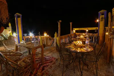 a table and chairs on a patio at night at Dar Bejmate - Chez Hassan in Tacheddirt