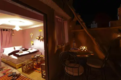 a bedroom with a bed and a table in a room at Dar Bejmate - Chez Hassan in Tacheddirt