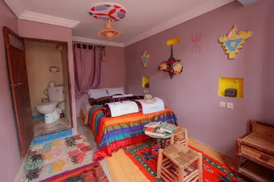 a bedroom with a bed with a soccer ball on the wall at Dar Bejmate - Chez Hassan in Tacheddirt