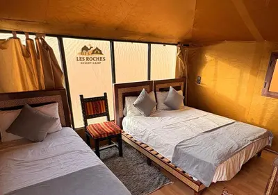 a bedroom with two beds in a tent at Les Roches Desert Camp in Merzouga