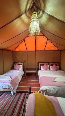 a room with three beds in a tent at Les Roches Desert Camp in Merzouga