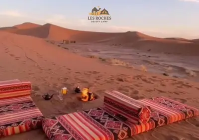 a camp in the desert with a bonfire at Les Roches Desert Camp in Merzouga