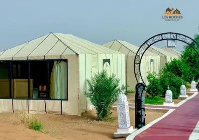 a building with a tent and an arch in front of it at Les Roches Desert Camp in Merzouga