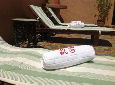 a stack of towels sitting on top of a bed at Riad Timadrouine, hôtel et restaurant in Tinerhir