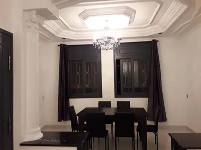 a dining room with a table and chairs and a chandelier at Appartement Moderne 3 Chambres in Fès