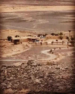 an old picture of a desert with rocks and a road at Maison Boutchrafine in Erfoud