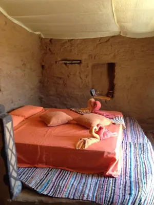a person laying on a bed in a room at Maison Boutchrafine in Erfoud