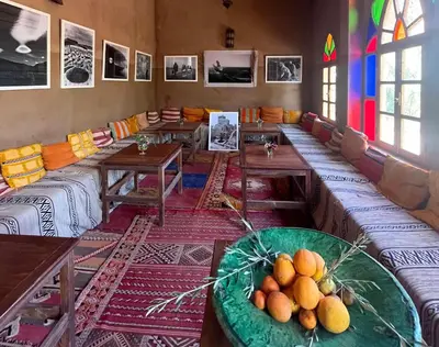 a room with couches and tables in a room at Hotel Carrefour des Nomades in Mhamid