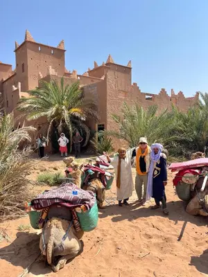 a group of people walking in front of a building at Hotel Carrefour des Nomades in Mhamid