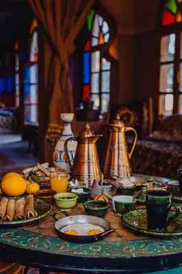 a table with plates of food and pitchers on it at Hotel Carrefour des Nomades in Mhamid
