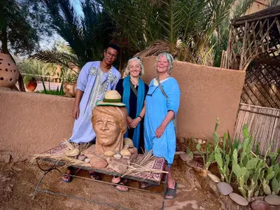 a group of people standing next to a statue at Hotel Carrefour des Nomades in Mhamid
