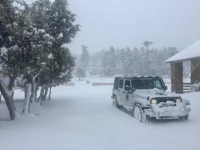 a jeep parked in the snow in front of a house at Atlas Crown - Chalet de luxe in Ifrane