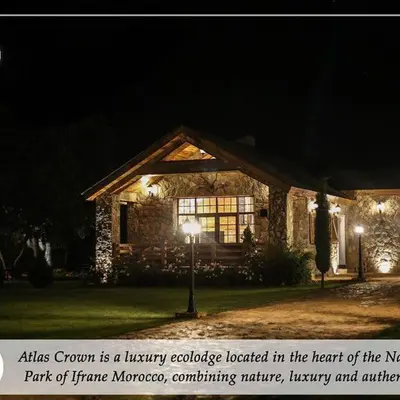 a stone house with lights in front of it at night at Atlas Crown - Chalet de luxe in Ifrane