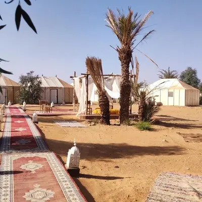 a fire hydrant on a dirt road with palm trees at Royal Luxury Cafe Du Sud in Merzouga