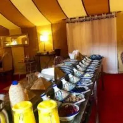 a long buffet line with bowls of food on it at Royal Luxury Cafe Du Sud in Merzouga