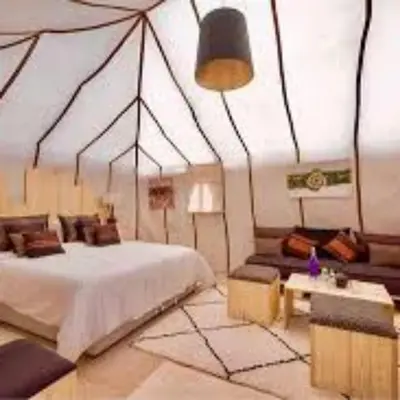 a bedroom with a large bed and a table at Royal Luxury Cafe Du Sud in Merzouga