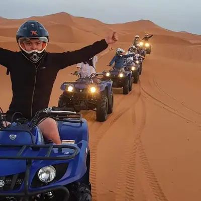 a group of people riding atvs in the desert at Royal Luxury Cafe Du Sud in Merzouga