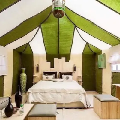 a bedroom with a bed with green and white walls at Royal Luxury Cafe Du Sud in Merzouga