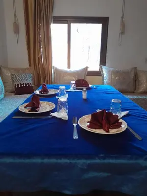 a blue table with plates and napkins on it at maison isabel in Boumalne