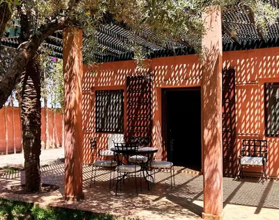 a patio with a table and chairs in front of a building at Villa Sophia in Azib Oulad Lâdem